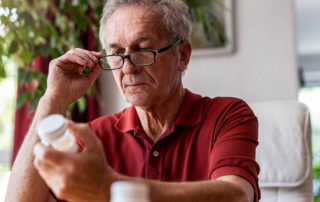 Senior examining vitamin or pill bottle